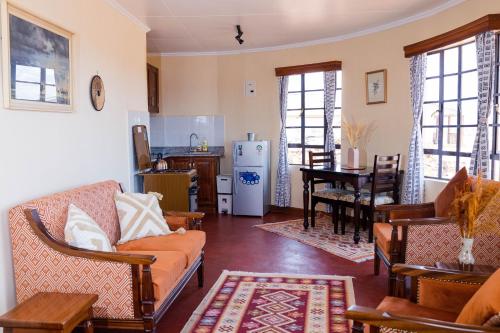 安博塞利Wild Amboseli Ndovu Cottage.的客厅配有沙发和桌子