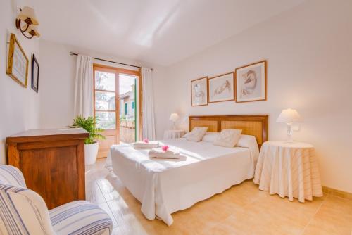 萨拉比塔Blau Mari 2 PAX的卧室配有一张白色大床和两把椅子