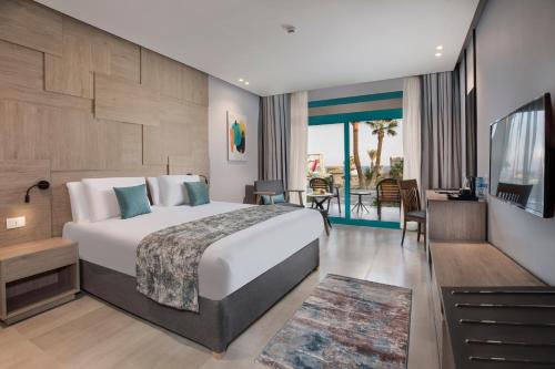沙姆沙伊赫Pyramisa Beach Resort Sharm El Sheikh的酒店客房设有一张床和一个阳台。