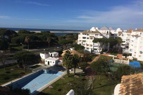 埃尔波提尔Coqueto apartamento a un tiro de piedra de la playa del Portil的享有带游泳池的度假村的空中景致