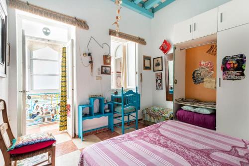 加的斯Habitaciones La Pepa的一间卧室配有一张床、一张桌子和一个窗户。