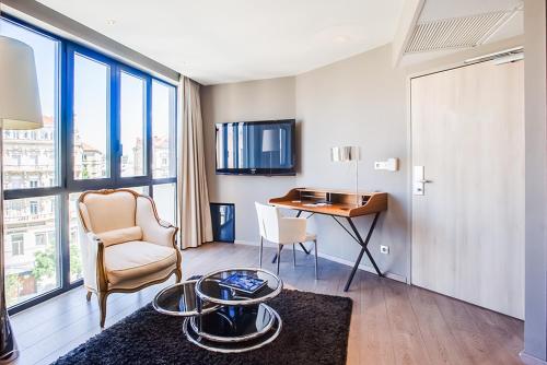 瓦朗斯法兰西酒店的客厅配有桌子和椅子