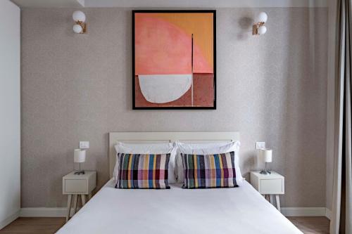 佛罗伦萨numa I Fiore Apartments的一间卧室配有带两个枕头的床和一幅画
