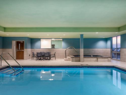 沃特敦Holiday Inn Express & Suites - Watertown, an IHG Hotel的游泳池位于酒店带用餐室的房间内