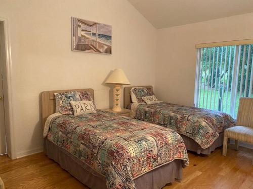 克莱蒙Stever Llc的一间卧室设有两张床、一盏灯和一扇窗户。