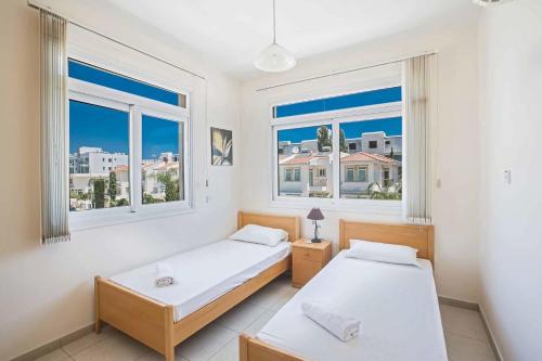 普罗塔拉斯Villa Attis的带2扇窗户的客房内的2张床