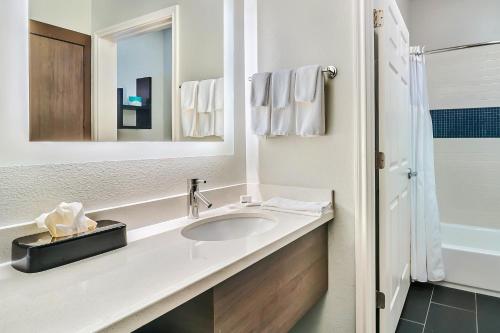 泰勒泰勒大学区驻桥套房酒店的白色的浴室设有水槽和镜子