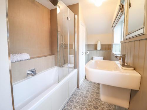 多尔盖罗3 Ivy Court的一间带水槽、浴缸和卫生间的浴室