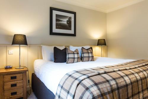 巴洛赫Cameron House Lodges的一间卧室配有一张大床和两盏灯。