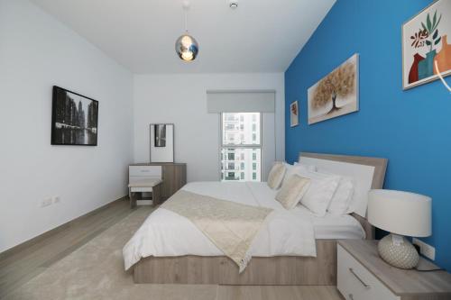 阿布扎比Yas Island - 2 Bedrooms, 2 toilet with shared Pool & Parking的一间卧室设有一张蓝色墙壁的大床