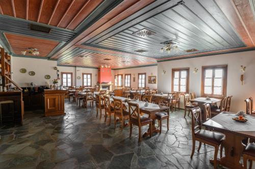 切佩洛沃芭比格迪斯酒店 的餐厅设有木桌、椅子和窗户。