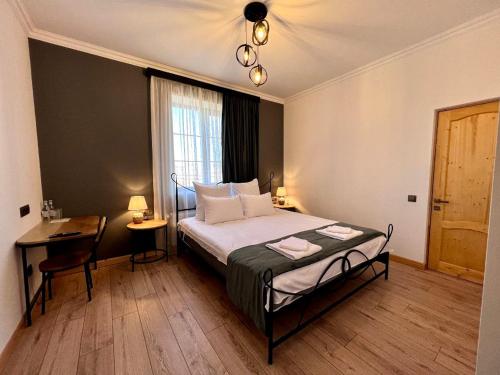 塞凡Sargsyan ECO house的一间卧室配有一张床、一张书桌和一个窗户。
