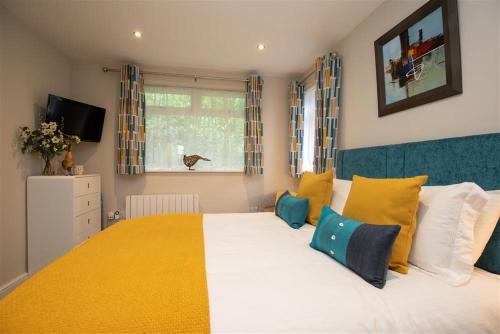 格拉斯米尔Silver Howe的一间卧室配有一张大床,提供黄色和蓝色的枕头