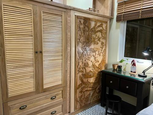 胡志明市Anam Homestay的一间卧室配有木制橱柜和一张书桌