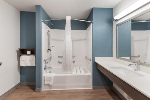 代顿WoodSpring Suites Dayton North的带淋浴、浴缸和盥洗盆的浴室