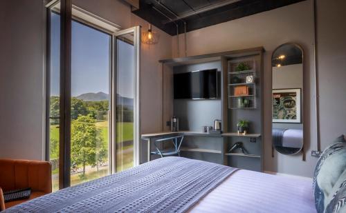 基拉尼Hotel67的一间卧室设有一张床和一个大窗户