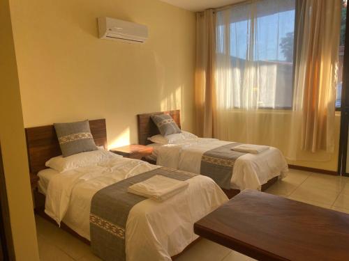 La GaritaVilla Garita Inn的酒店客房设有两张床和窗户。