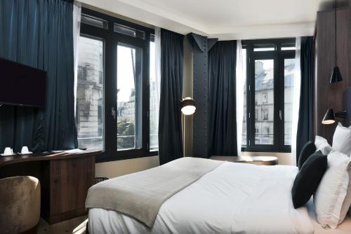 巴黎卡索奥酒店的一间卧室设有一张大床和窗户。