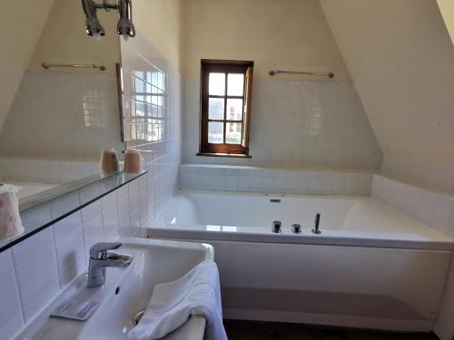 埃特勒塔火精灵庄园公寓酒店的白色的浴室设有浴缸和水槽。