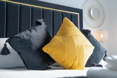 阿伯丁Brulee House - Luxury 2 Bed Apartment in Aberdeen Centre的床上的2个黑色和黄色枕头