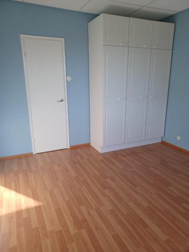 福尔萨HH Huoneistot kaksio parvekkeella的一间空房间,配有白色的橱柜和木地板