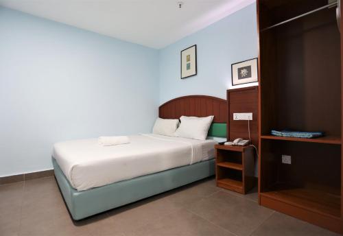 吉隆坡Orkid Hills Hotel的一间小卧室,配有床和床头柜