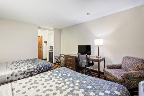 密尔沃基密尔沃基机场伊克诺旅店的酒店客房 - 带两张床、一张桌子和一把椅子