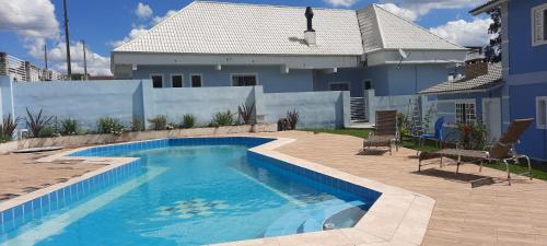 拉热斯POUSADA BLUE GARDEN的房屋前的游泳池