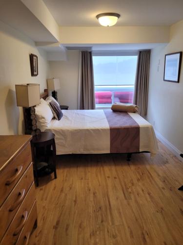卡灵港Muskoka Lakes Hotel and Resorts的一间卧室设有一张大床和一个窗户。