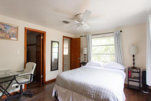 杰克逊维尔海滩Cozy 1 Bedroom Unit - 4 Blocks from Jax Beach Pier!的一间卧室配有一张床、一张桌子和吊扇