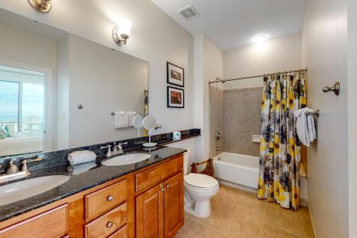 摩根堡The Indies #609的浴室配有盥洗盆、卫生间和浴缸。