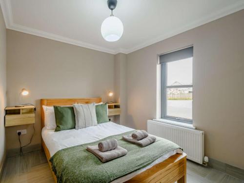 巴洛赫Westertonhill Lodge 5 Newbuild with Hot Tub Option的一间卧室配有带毛巾的床