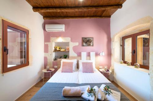 加瓦洛霍里翁Cretan Lux Villa Heated Pool的卧室配有白色的床铺和粉红色的墙壁