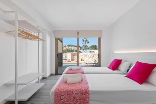 卡拉恩·布拉內斯VILLA NOKA的白色卧室配有带粉红色枕头的大床