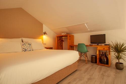 拉戈阿Azores Country Nature的一间卧室配有一张床和一张书桌及电视