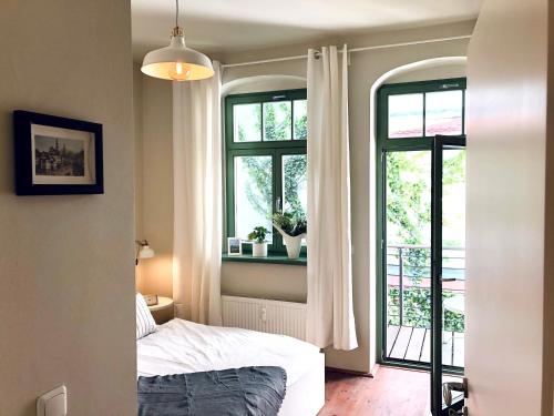 皮尔纳Hip & Minimalist - Stadt Apartments am Malerweg的一间卧室设有一张床和两个窗户。
