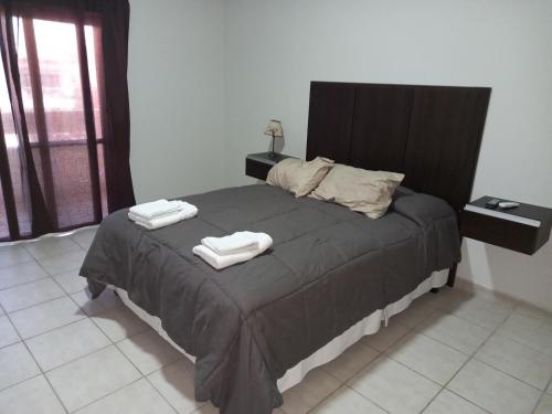 La ConsultaNueva Era Apart的一间卧室配有一张床,上面有两条毛巾