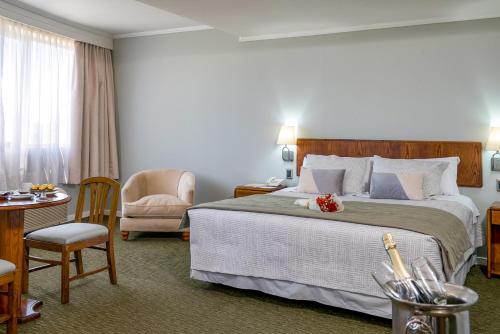 康塞普西翁地亚哥德阿尔马格罗康塞普西翁酒店的酒店客房带一张大床和一把椅子