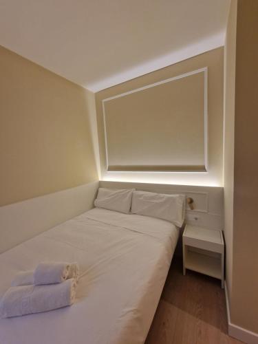 马德里Le Petit Palü- Barco的一间小卧室,配有一张白色的床和灯