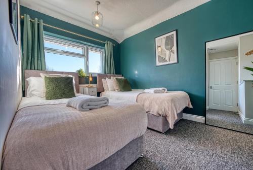赛伦塞斯特Stratton Heights by Apricity Property - 3 bedroom house, great for work or leisure, pet friendly的蓝色墙壁客房的两张床