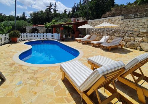 加瓦洛霍里翁Villa Nikolas的一个带躺椅和桌子的游泳池以及围栏