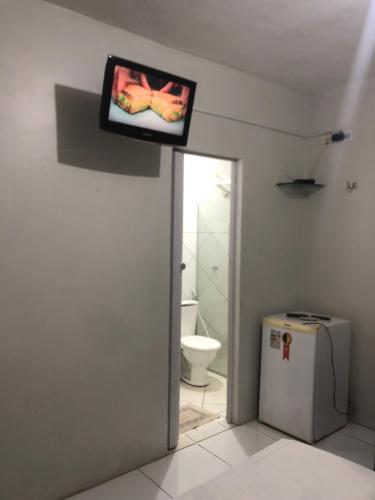 索布拉尔Brisa da Serra Pousada EM SOBRAL-CE的电视,浴室墙上的电视机,带厕所