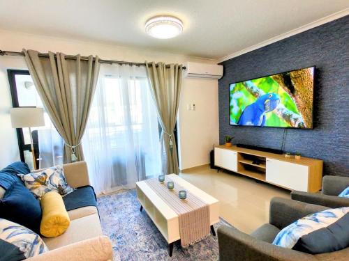 德班Pristine King Size Bed Apartment In Secure Complex的带沙发和平面电视的客厅