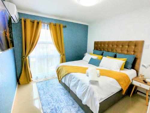 德班Pristine King Size Bed Apartment In Secure Complex的一间卧室配有一张黄色和蓝色的大床