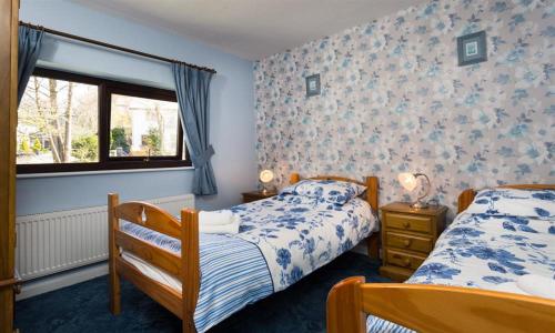 鲍内斯温德米尔Fairhaven的一间卧室设有两张床和窗户。