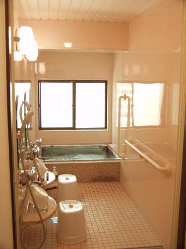 高山Oyado Raku的带浴缸、卫生间和盥洗盆的浴室