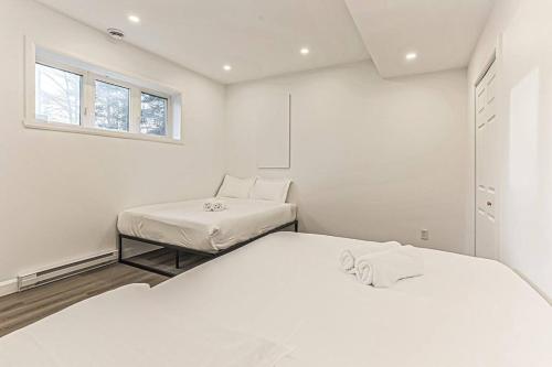 PrévostCheerful 4 bedroom home with inground heated pool的一间白色卧室,配有两张床和窗户