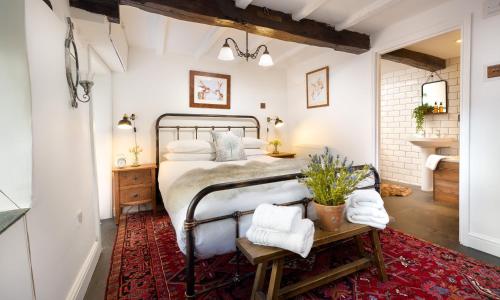 霍克斯黑德Craftsman Cottage的一间卧室配有一张床和红色地毯