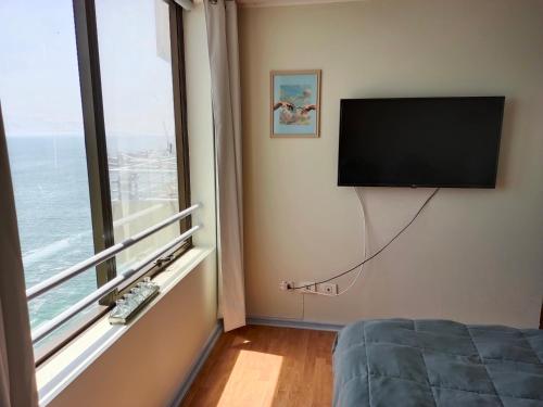 安托法加斯塔Espectacular Departamento frente al mar的卧室设有平面电视和窗户。
