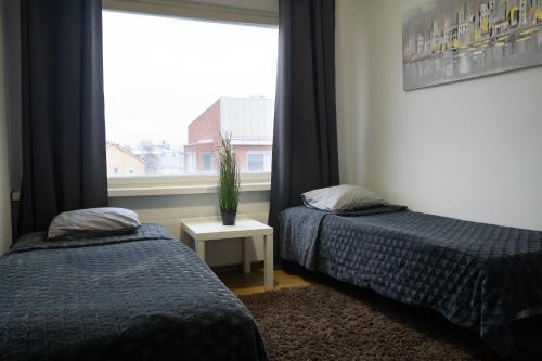 奥卢4-room apartment. Oulu city center的两张床位于带窗户的房间内